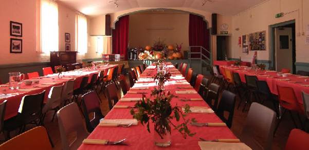 Long table with red tablecloths and flowers
AI-generated content may be incorrect.