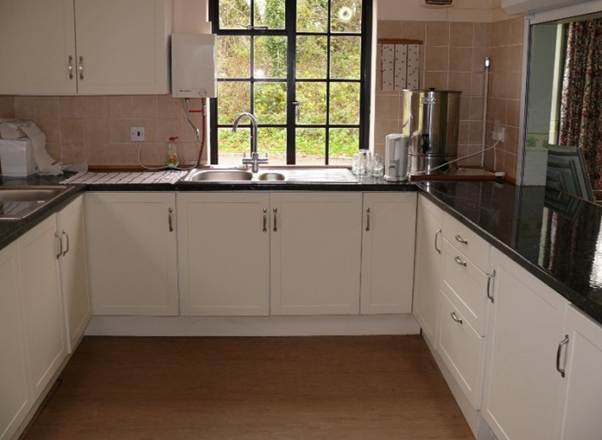 A kitchen with white cabinets and black counter tops
AI-generated content may be incorrect.